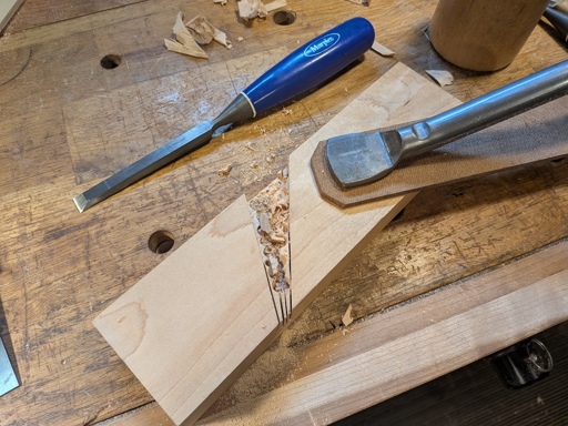 A partially finished rabbet plane body sitting on a bench